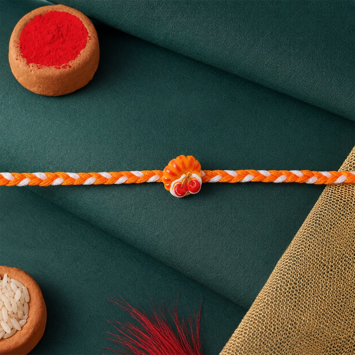 Top view of cherry pastry charm rakhi