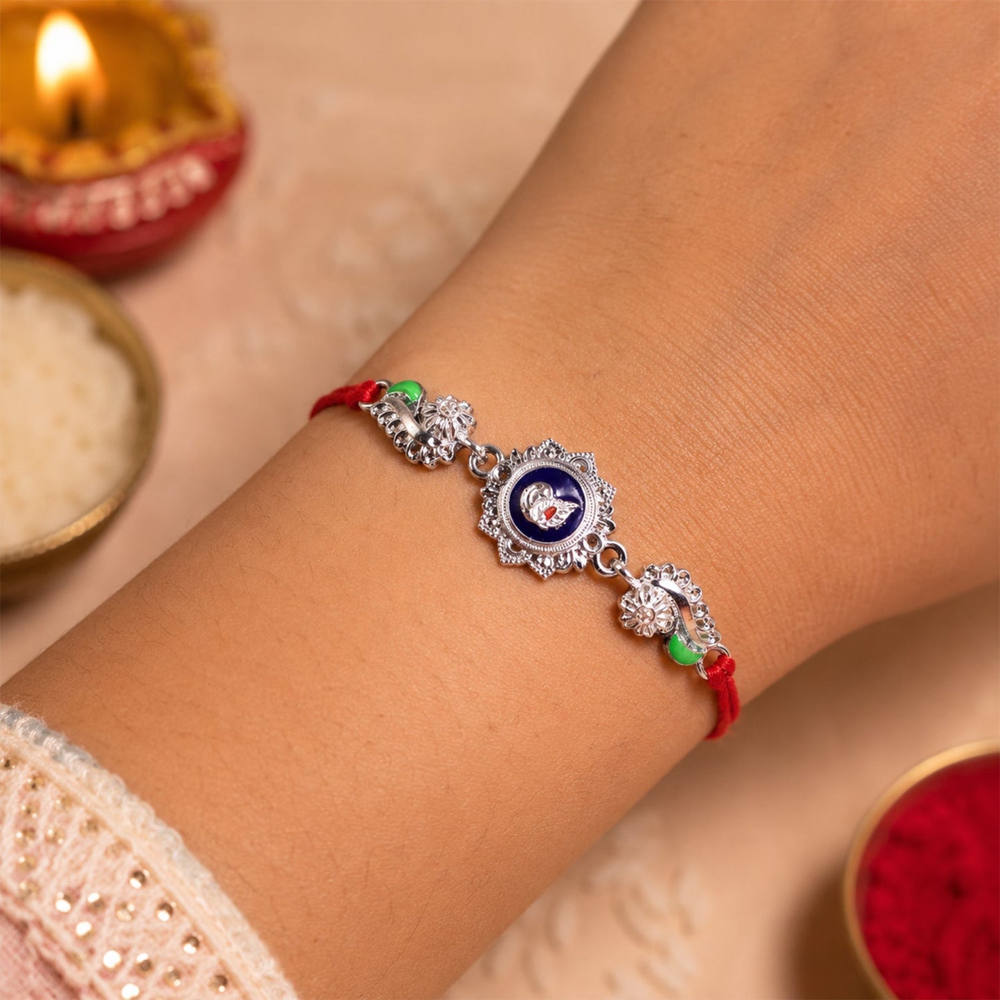 Silver charm rakhi tied with red thread