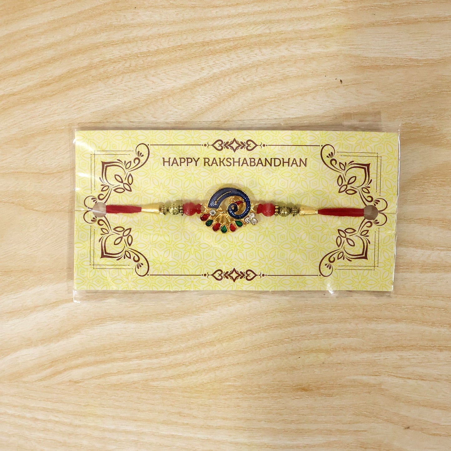 Colorful Peacock Charm Rakhi with red beads tied string