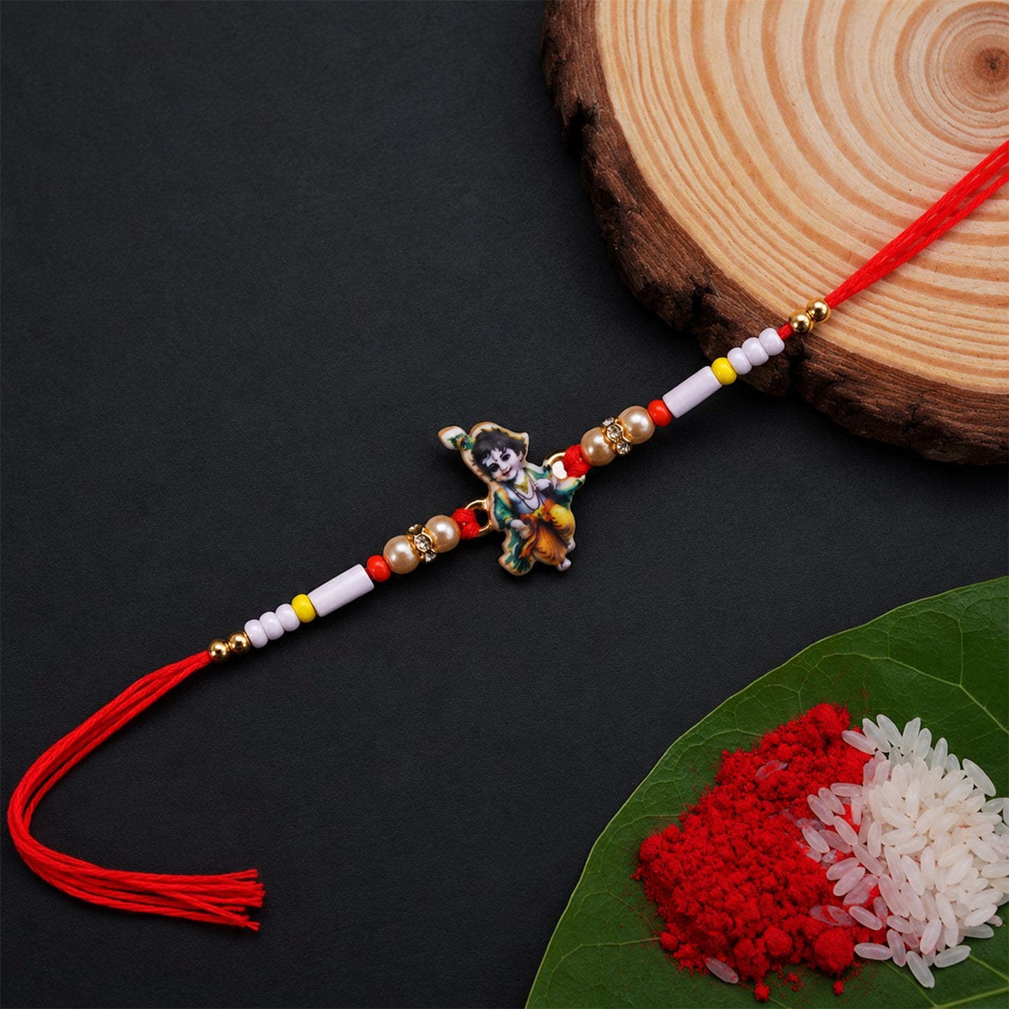 Close-up of Krishna Idol Charm on Rakhi