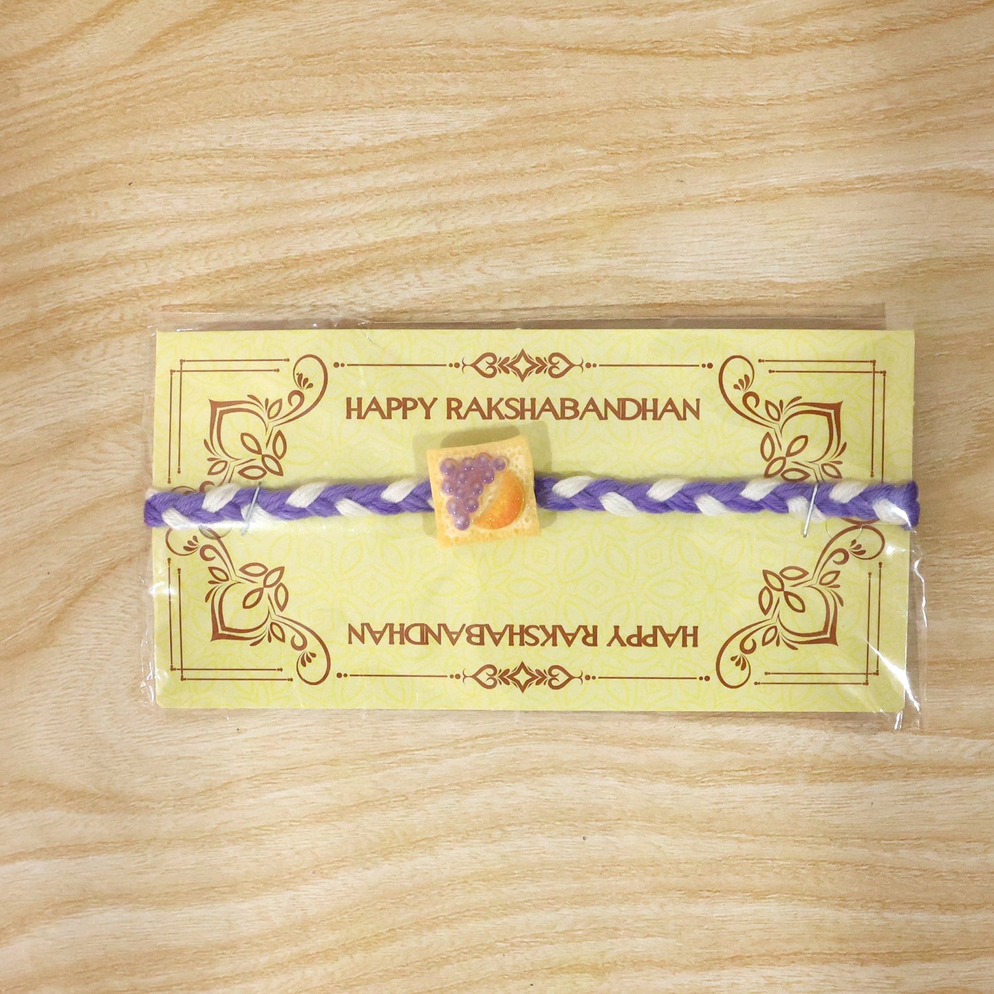Decorative Fruit Toast Charm Rakhi with braided thread close up
