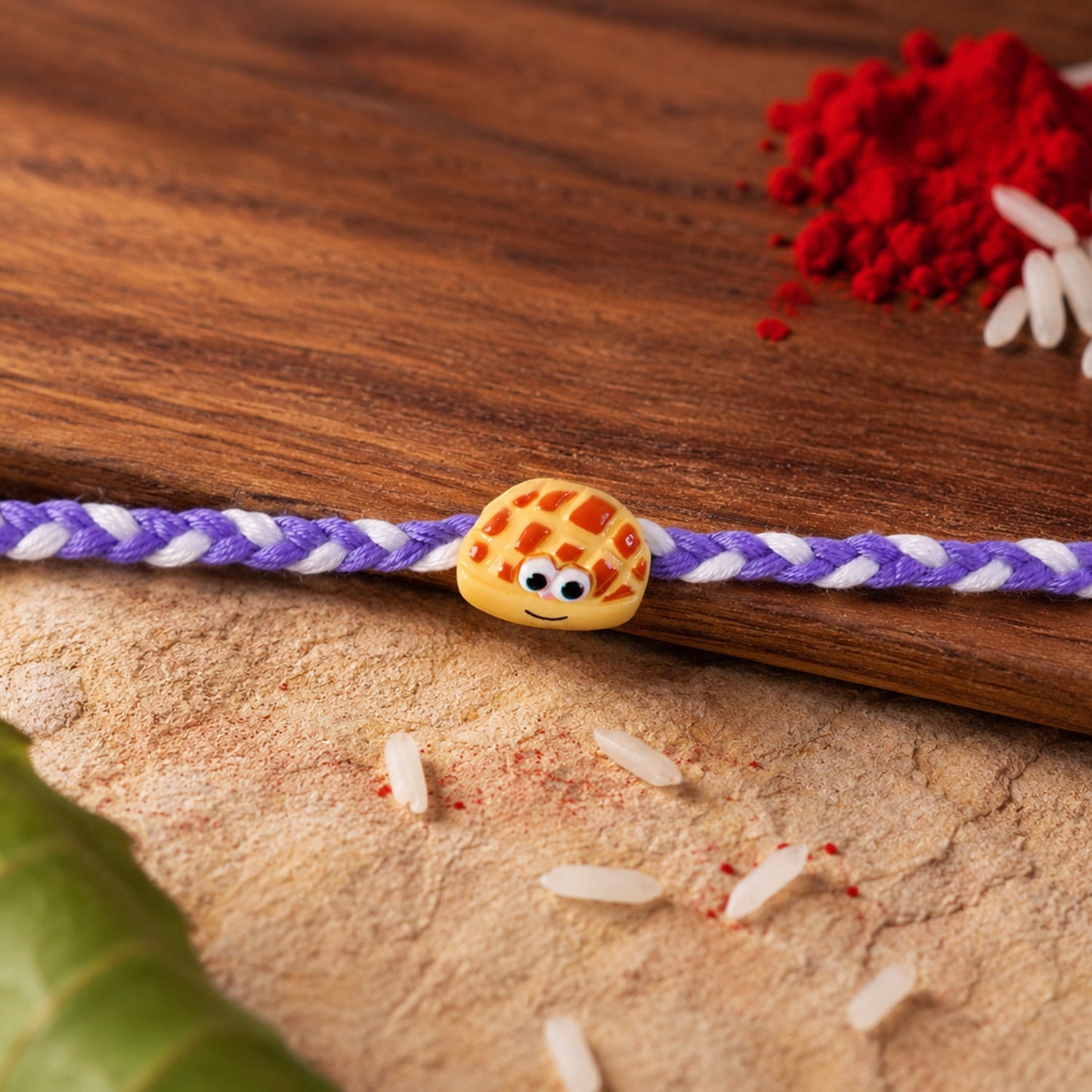 Side view of Smiley Waffle Charm Braided Thread Rakhi