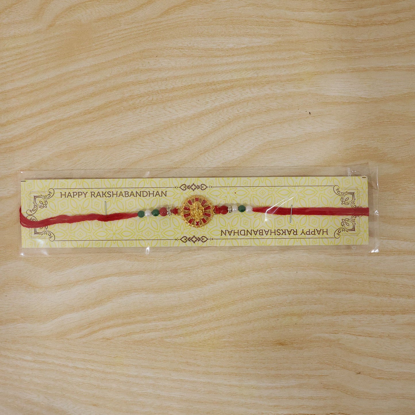 Golden Ganesha Wheel Rakhi with Red Enamel