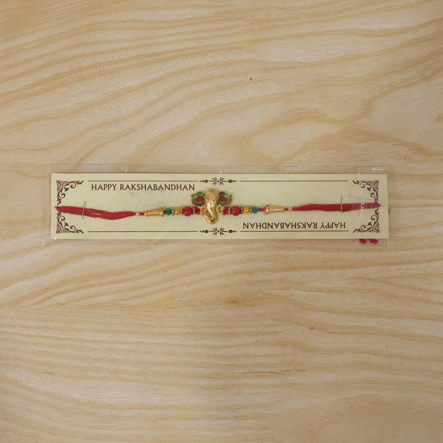 Lord Ganesha Golden Meenakari Rakhi with Red & Green Beads for Brother