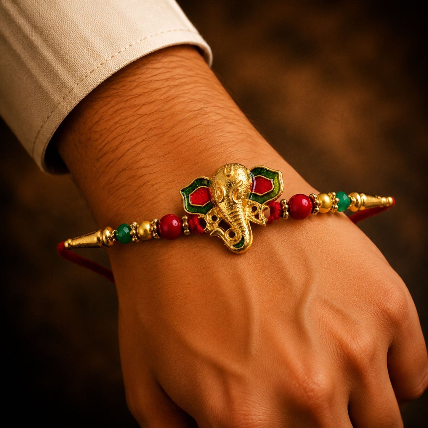 Lord Ganesha Golden Meenakari Rakhi with Red & Green Beads for Brother