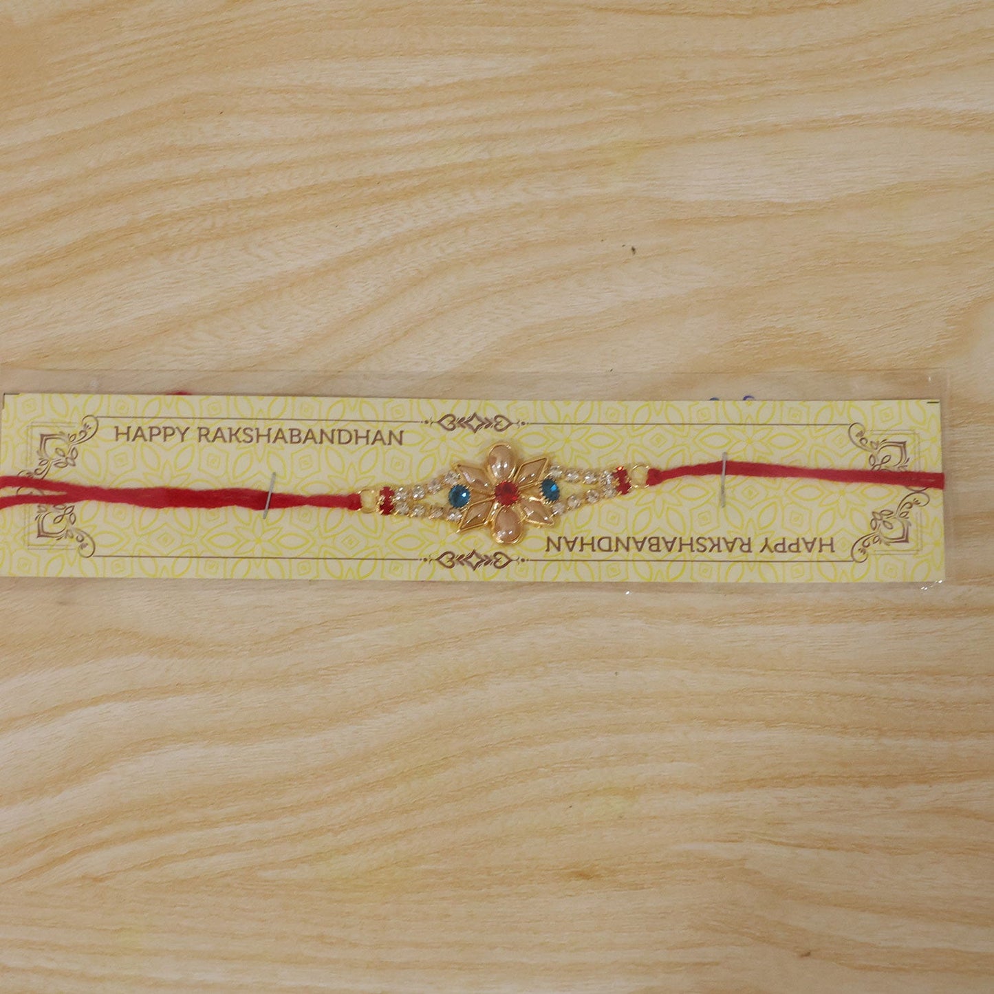 Designer Pearl Flower Rakhi with Blue & Red Stones for Brother