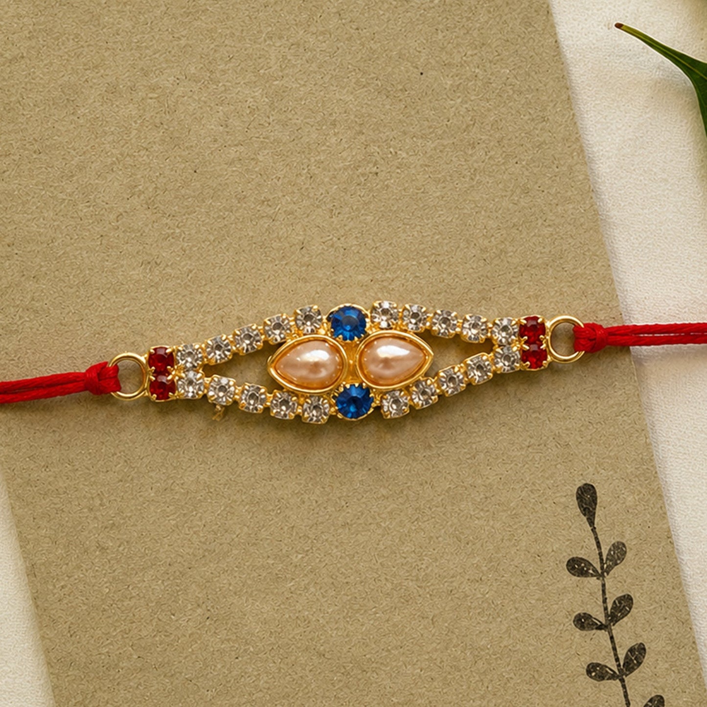 Royal Pearl & AD Stone Rakhi with Blue & Red Stones for Brother