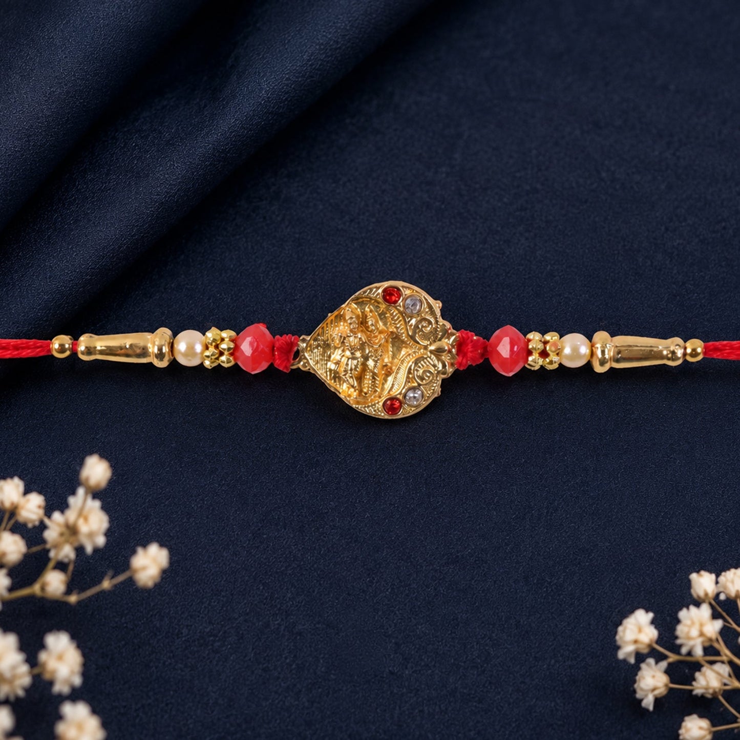 Golden Ganesha Oval Rakhi with Red Crystal Beads