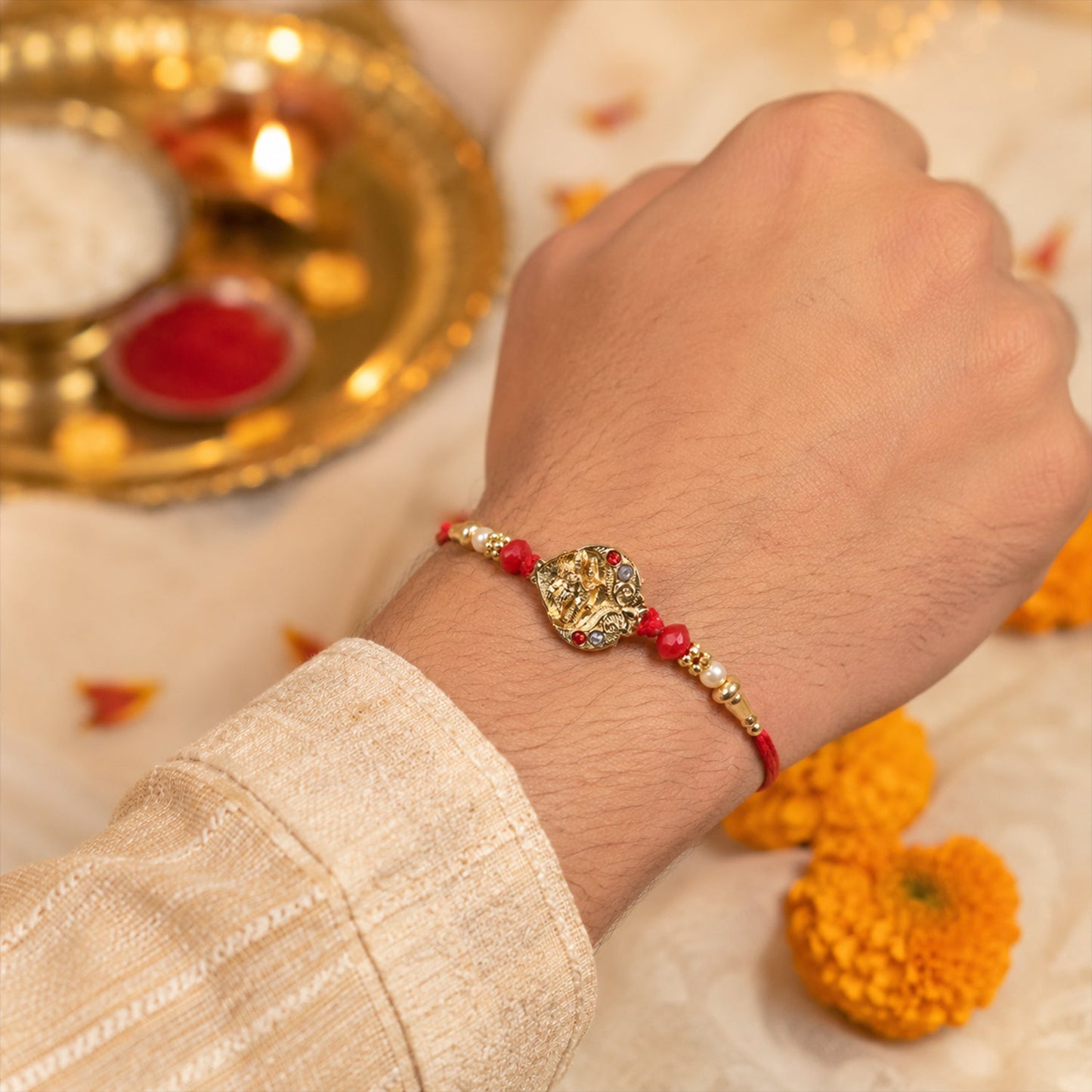 Golden Ganesha Oval Rakhi with Red Crystal Beads