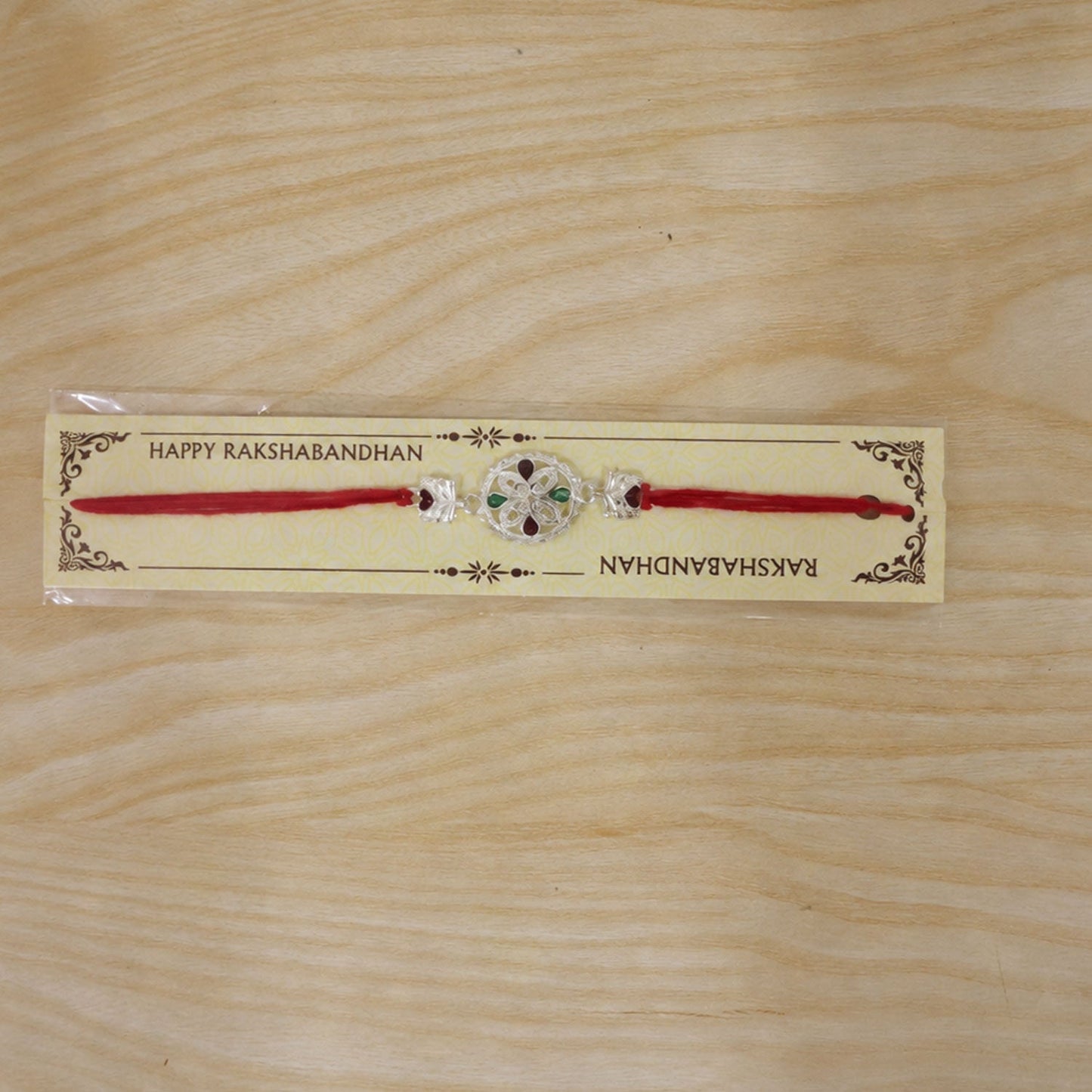 Silver Floral Rakhi with Red & Green Teardrop Stones