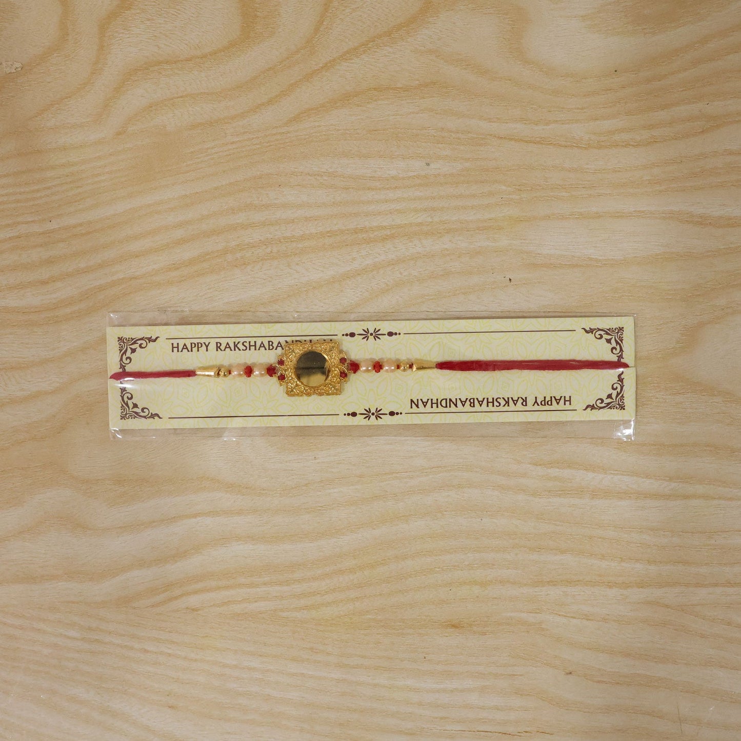 Golden Square Frame Rakhi with Pearls & Red Beads