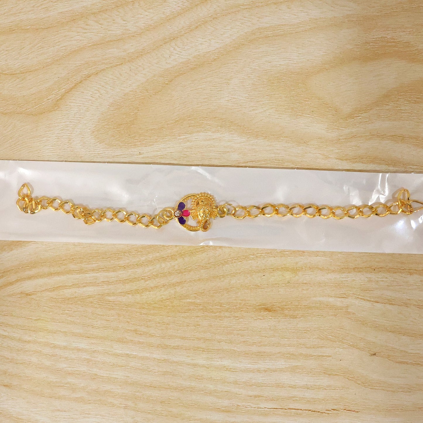 Lord Ganesha gold tone rakhi bracelet styled on wrist