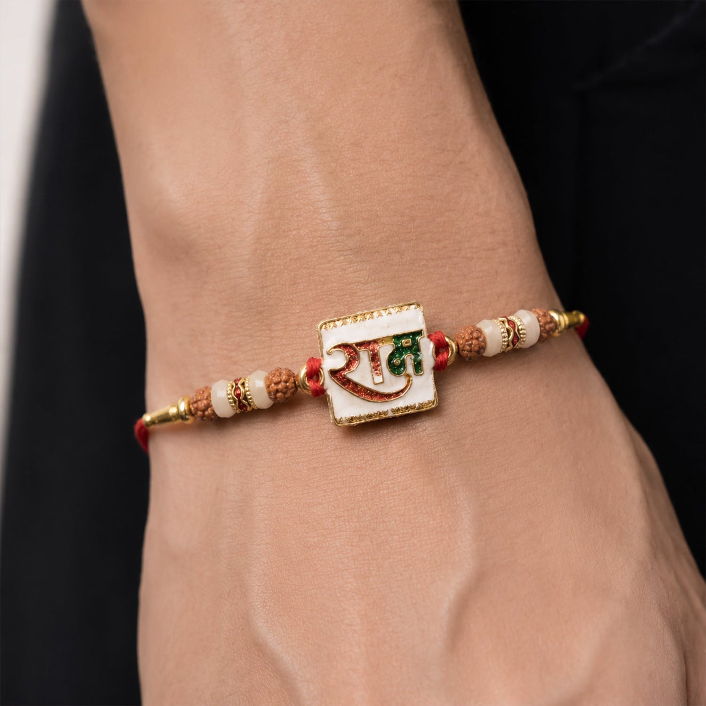 Side view of Ram Text White Enamel Gold Tone Rakhi