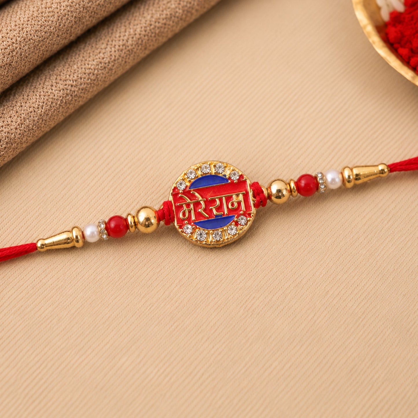 Mere Ram Text Gold Tone Rakhi on a white background