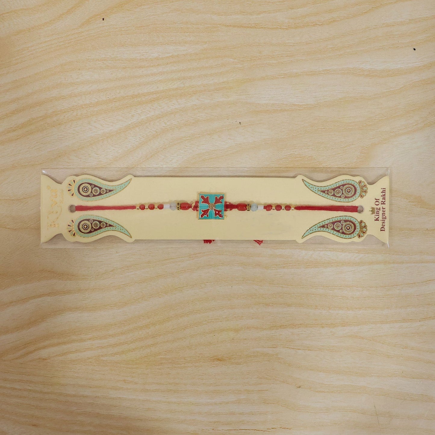 Overhead view of the Square Design Charm Kids Rakhi, showcasing its full design.