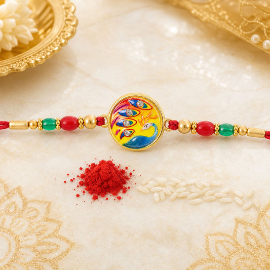 Close up of round meenakari peacock design rakhi for brother with crystal beads.