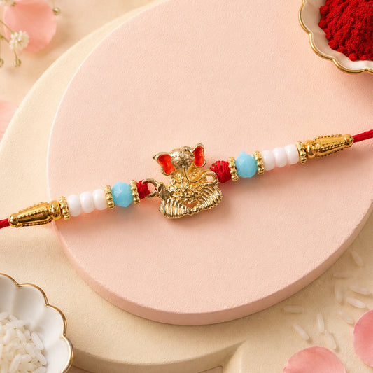 Golden Ganesha Rakhi with aqua blue and white beaded thread.
