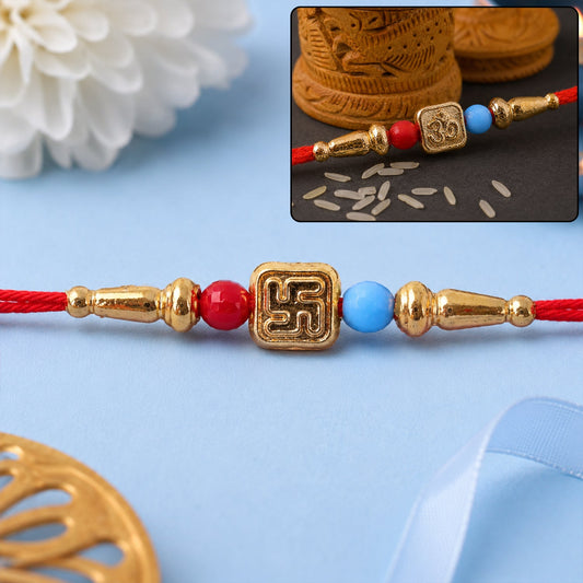 Swastik and Om symbol beaded rakhi with red and gold threads, laid flat.