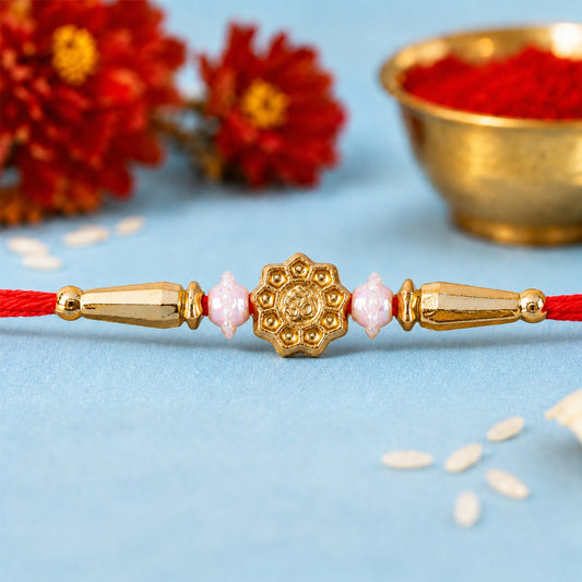 Close up of a Round Swastik Om Charm Rakhi with intricate detailing and red thread.