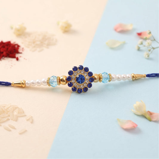 Close up of a sparkling floral diamond stone pearl crystal beads fancy rakhi on a white background.