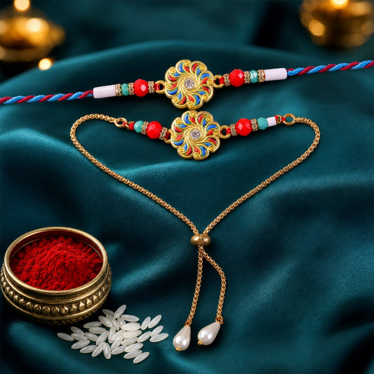 A gold and enamel floral Rakhi and a matching bracelet with pearls are displayed on a teal fabric with kumkum and rice.