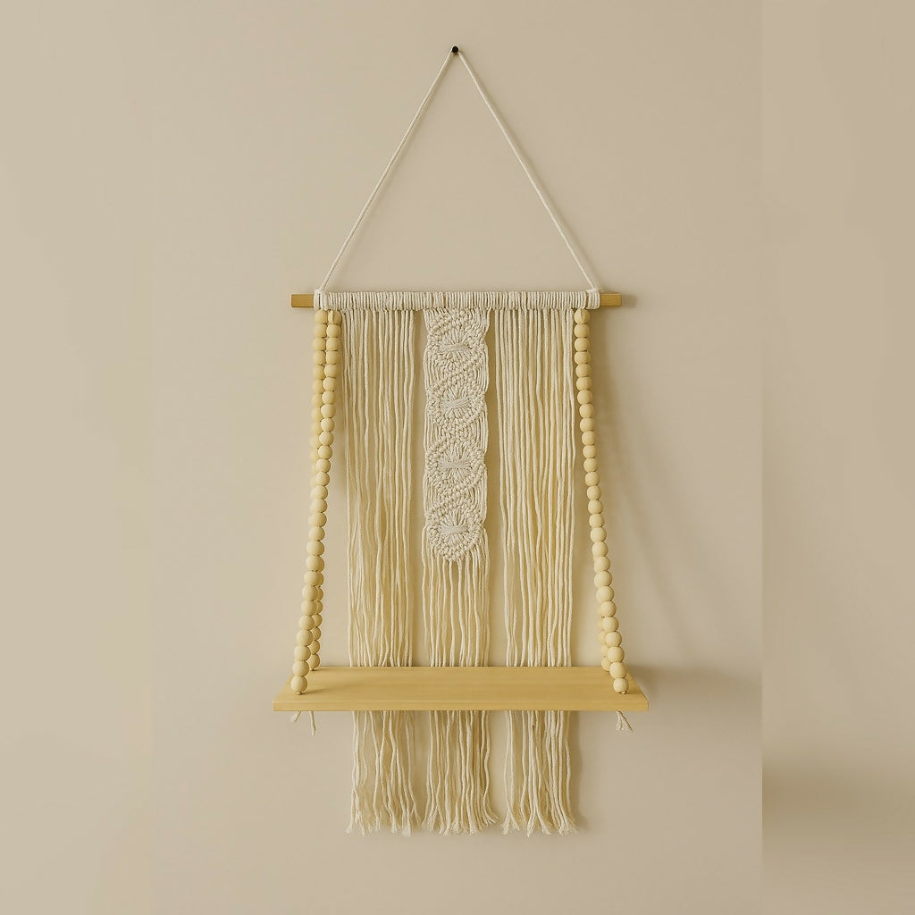 A macrame wall hanging shelf with a braided central design, natural wooden beads, and a light wooden shelf.