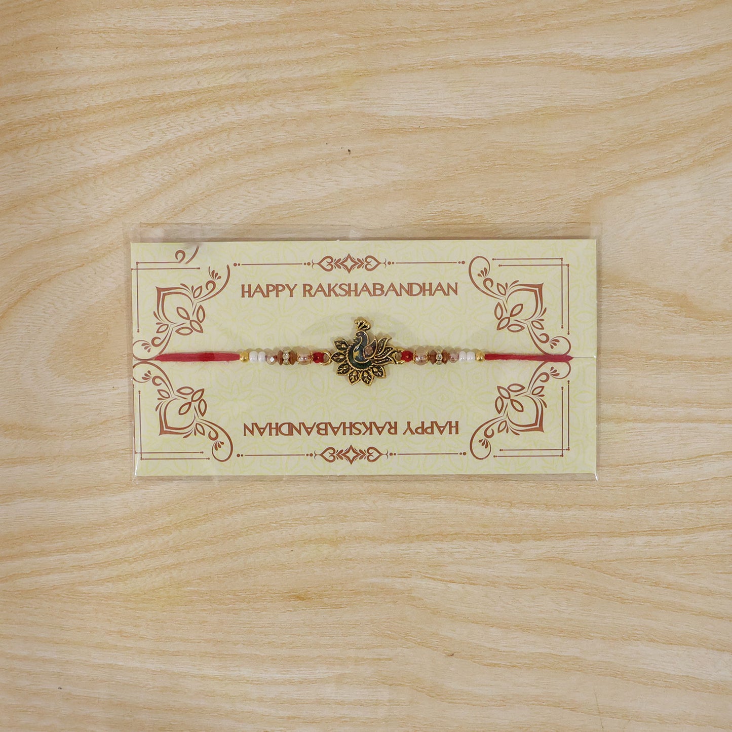 Peacock Floral Golden Rakhi with Blue Green Enamel, Pearl Beads and Red Thread