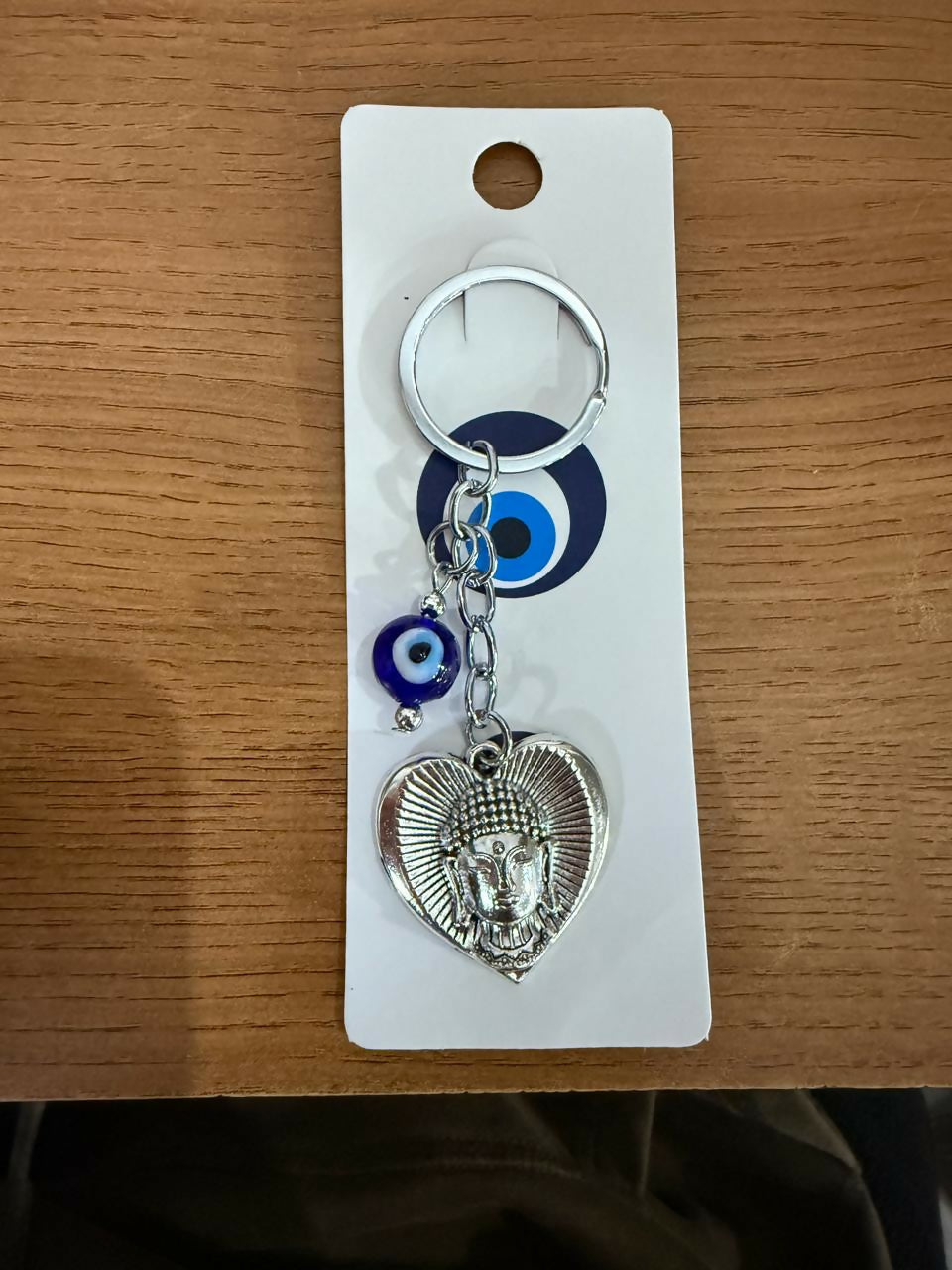 Buddha evil eye heart keychain displayed on a plain background
