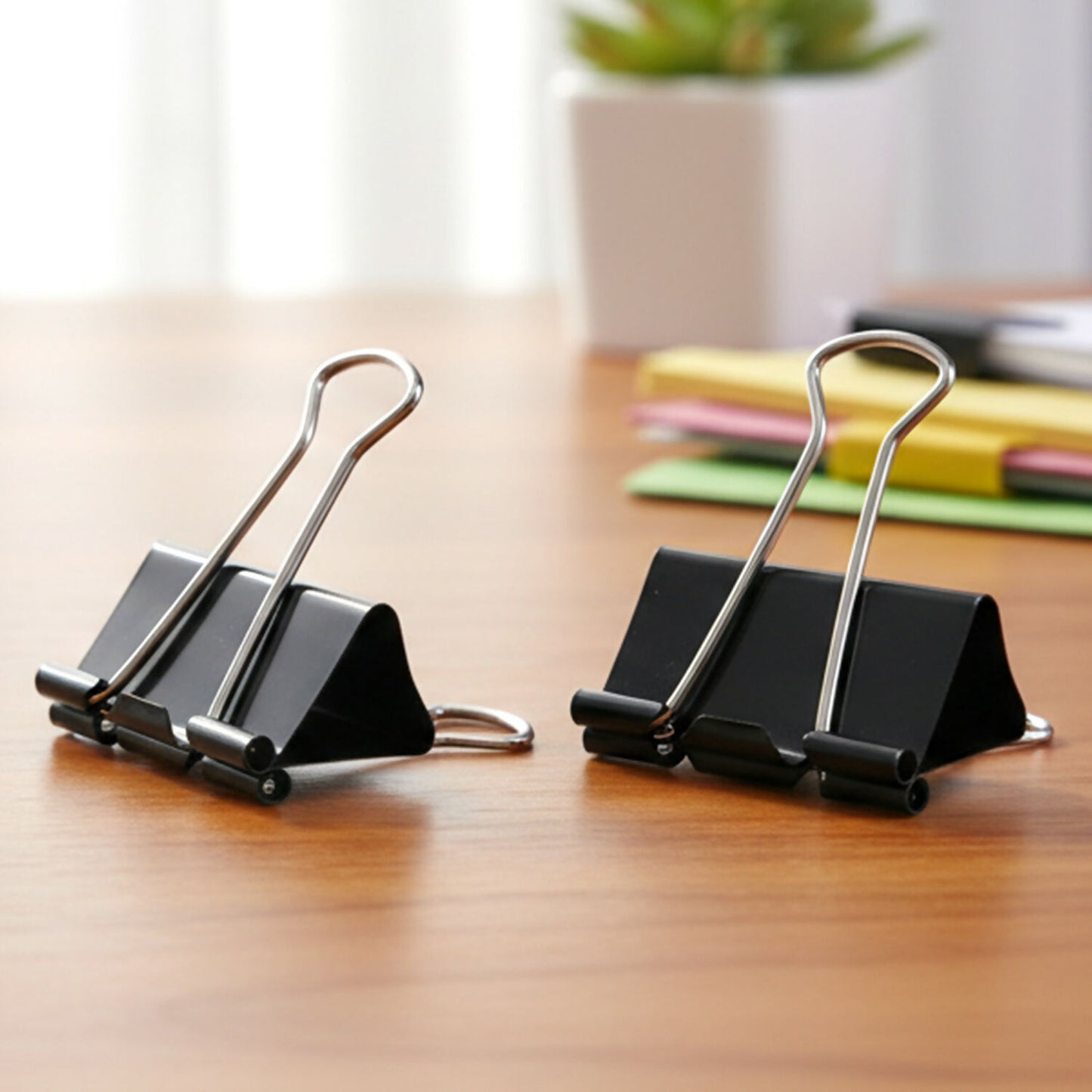 Black binder clips neatly arranged on a white surface