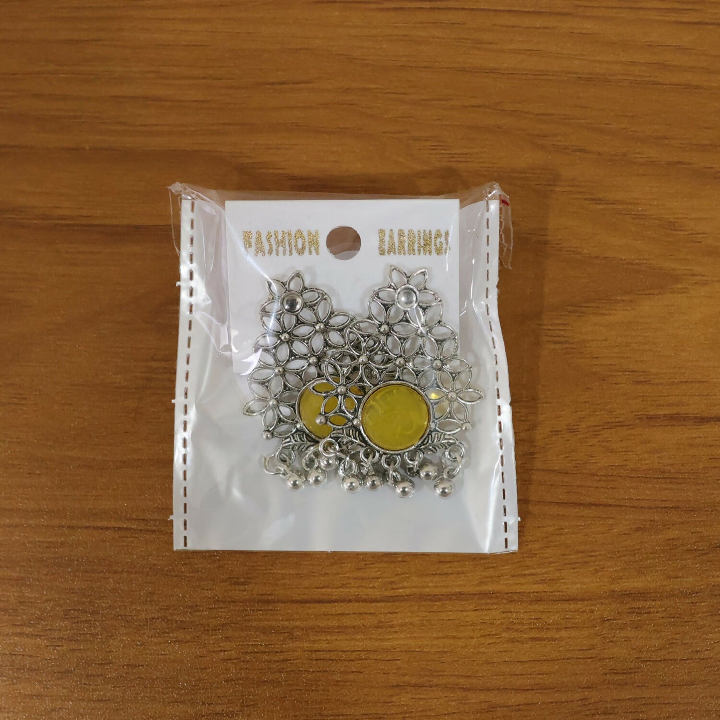 Front view of oxidized silver filigree earrings with yellow stone and dangles