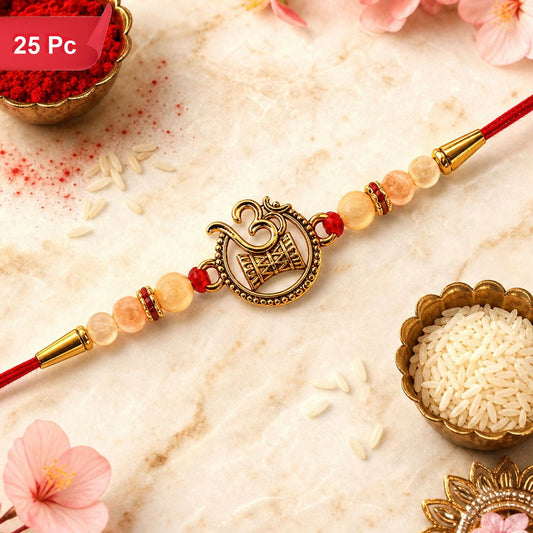 A red thread with a golden Om Swastik motif and pearl beads is surrounded by red powder and rice grains.