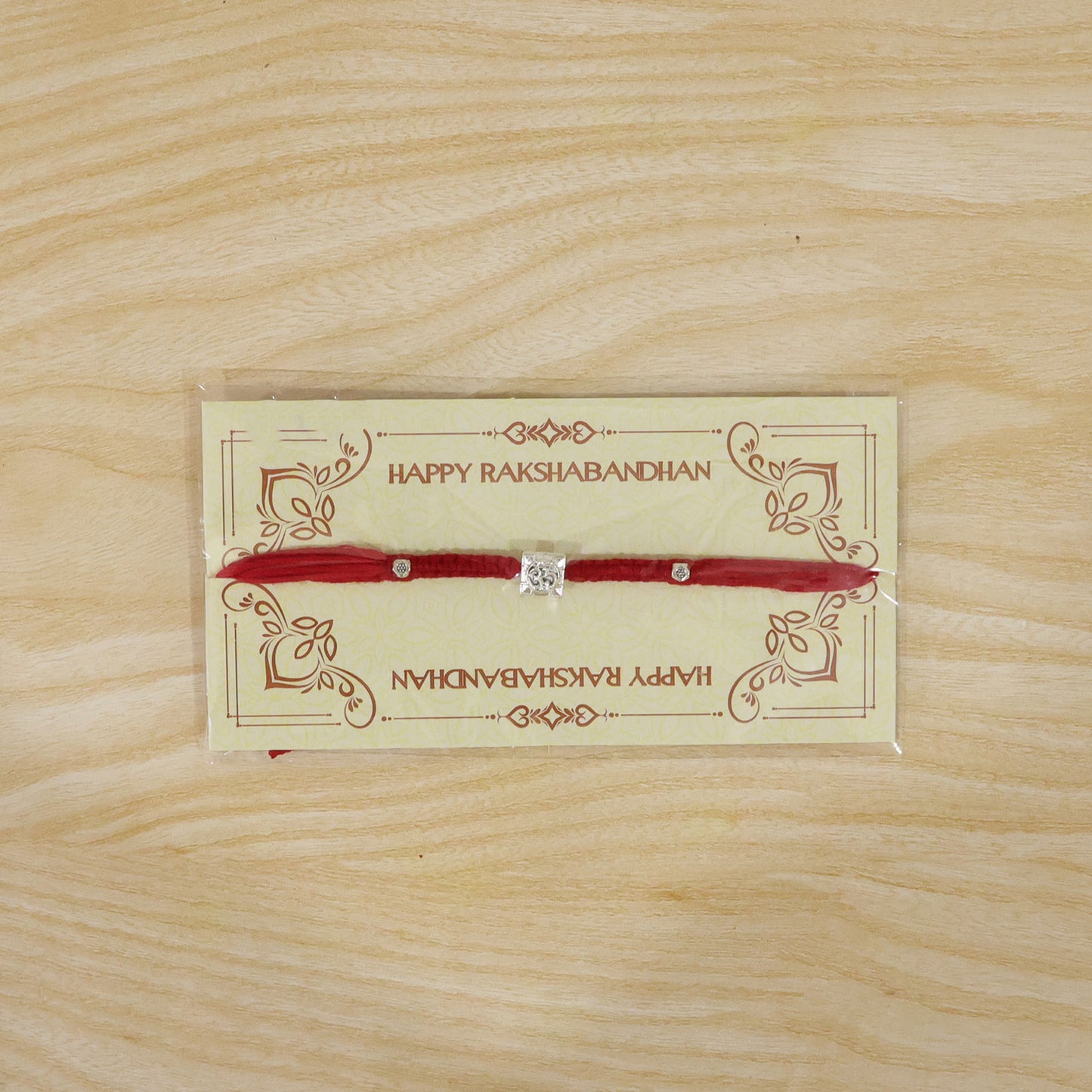 Red Braided Rakhi with Silver Om Pendant Set in a Square Frame