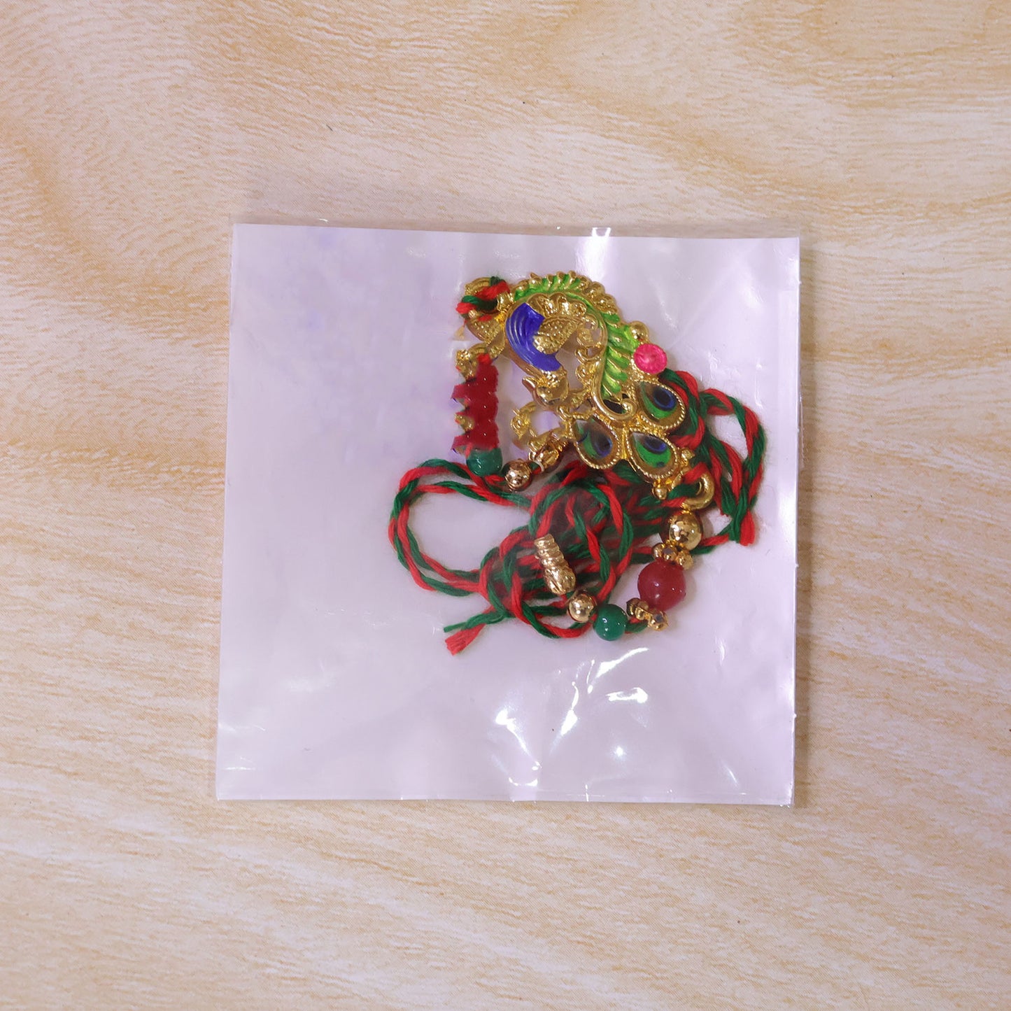 Green and Blue Peacock Enamel Pendant Rakhi with Red and Green Beads