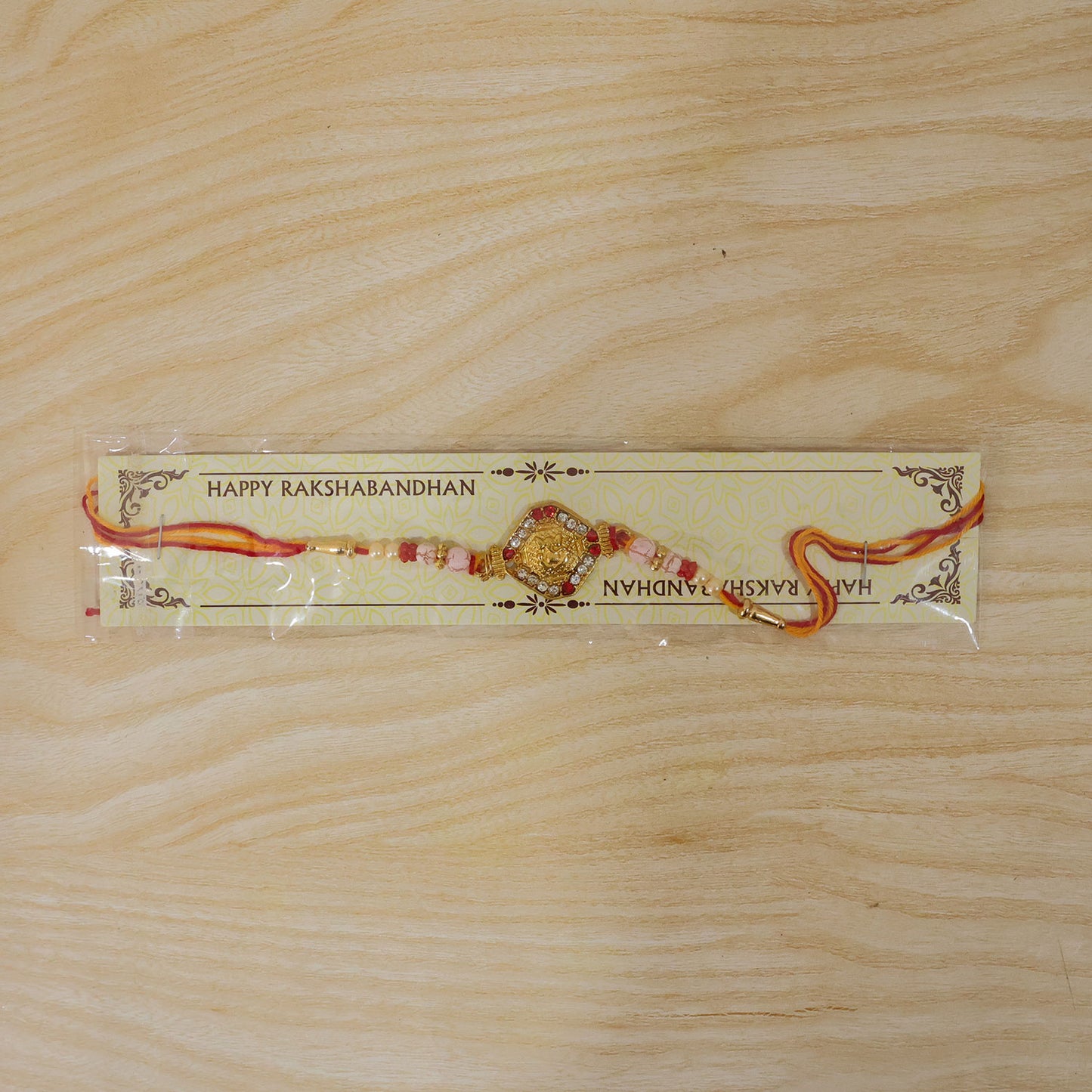 Ganesh Rakhi with Golden Beads and Red-Yellow Thread