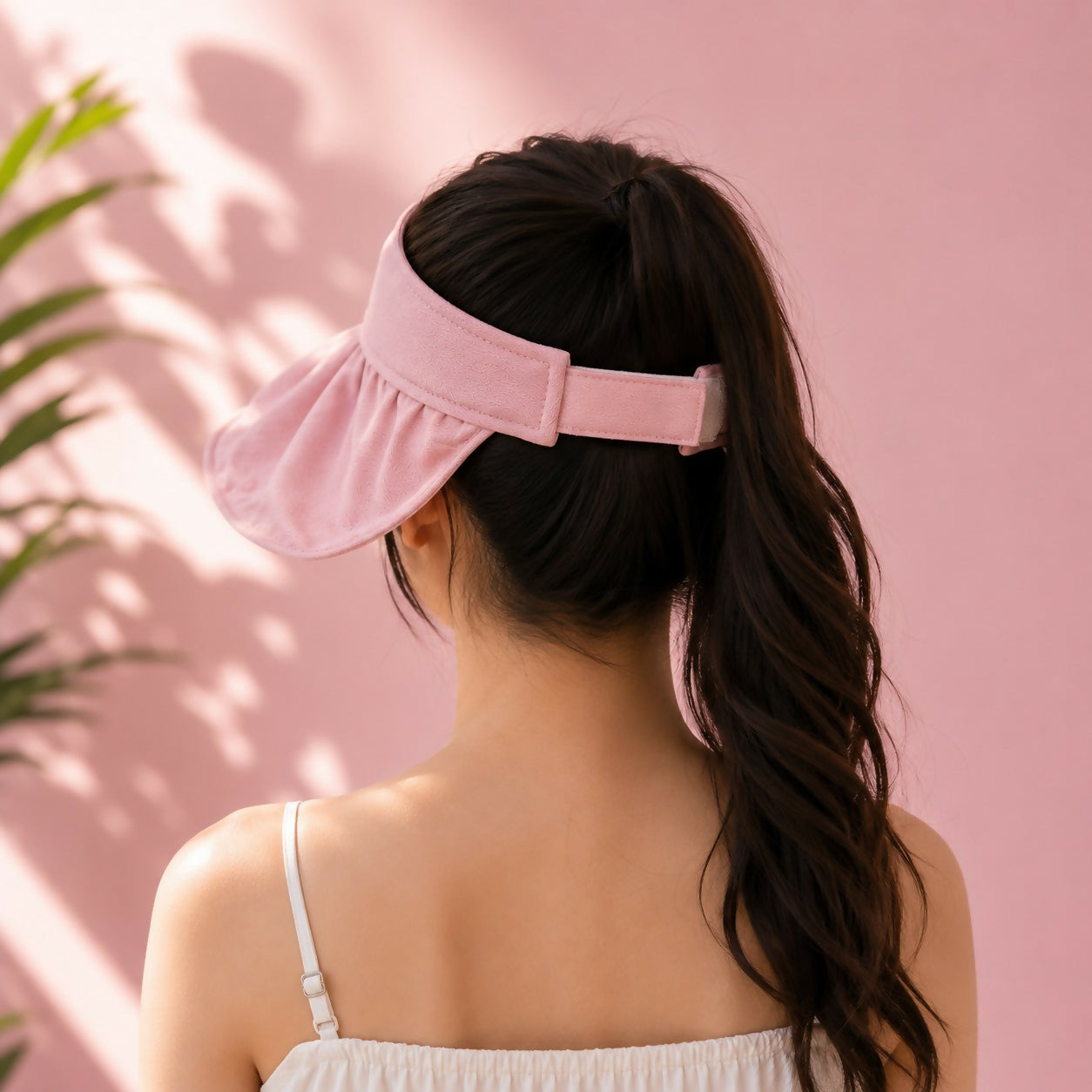 Foldable pink sun visor cap showing adjustable back strap