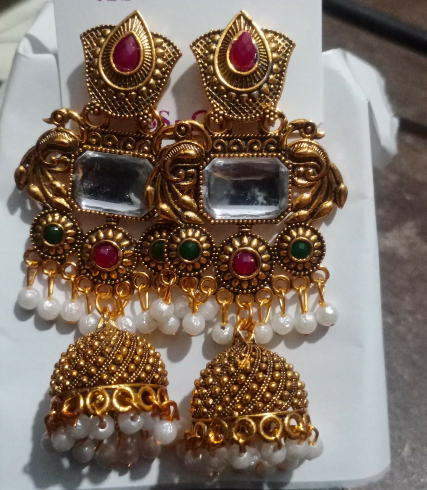 Traditional gold plated Kundan jhumka earrings worn on ear