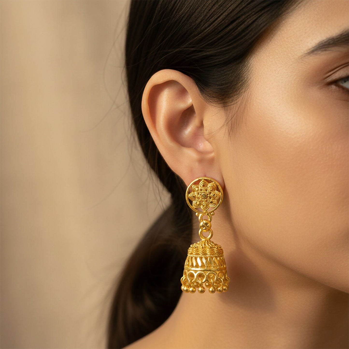 Close-up of intricate detailing on gold floral jhumka earrings