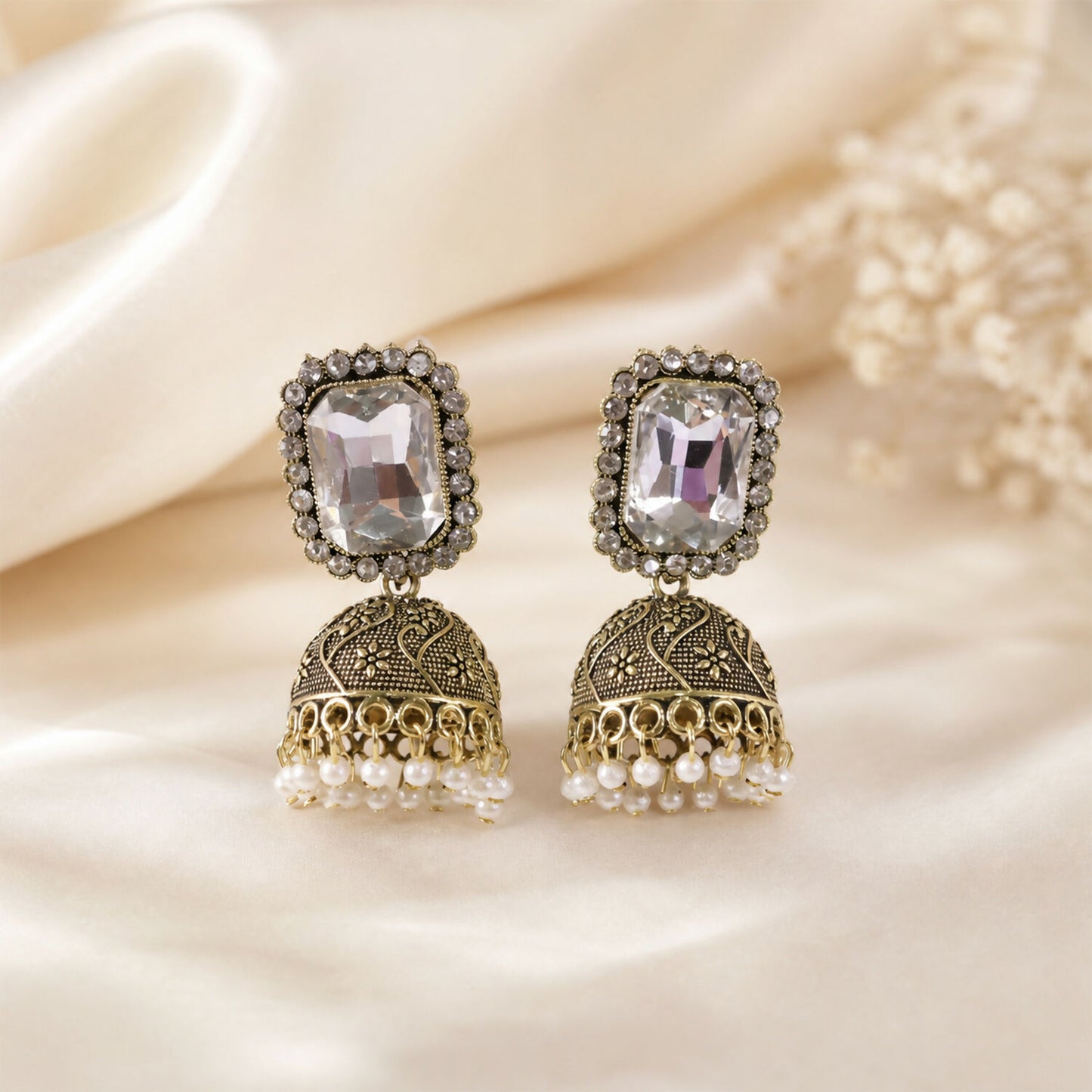 Close-up of pearl drop design on antique gold jhumka earrings