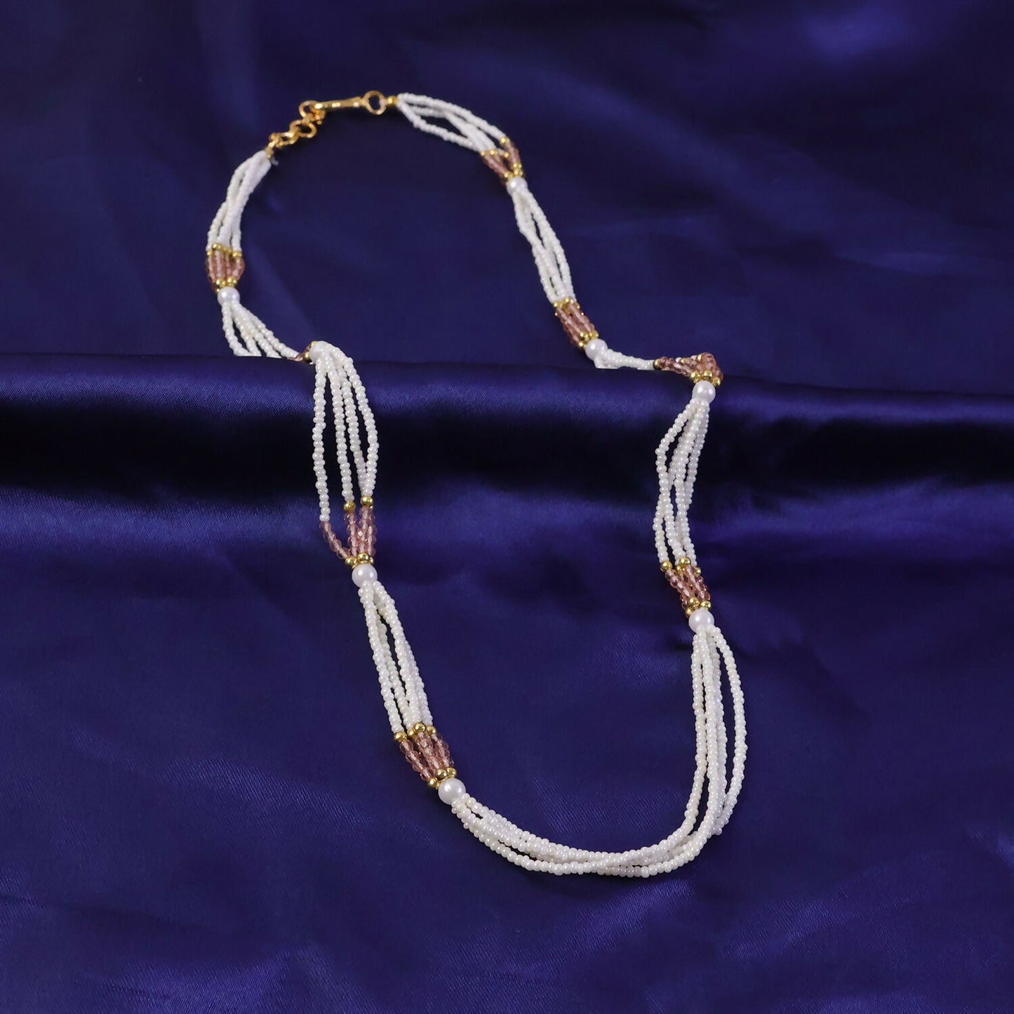 Close-up of pearl and peach beads on ethnic mala necklace