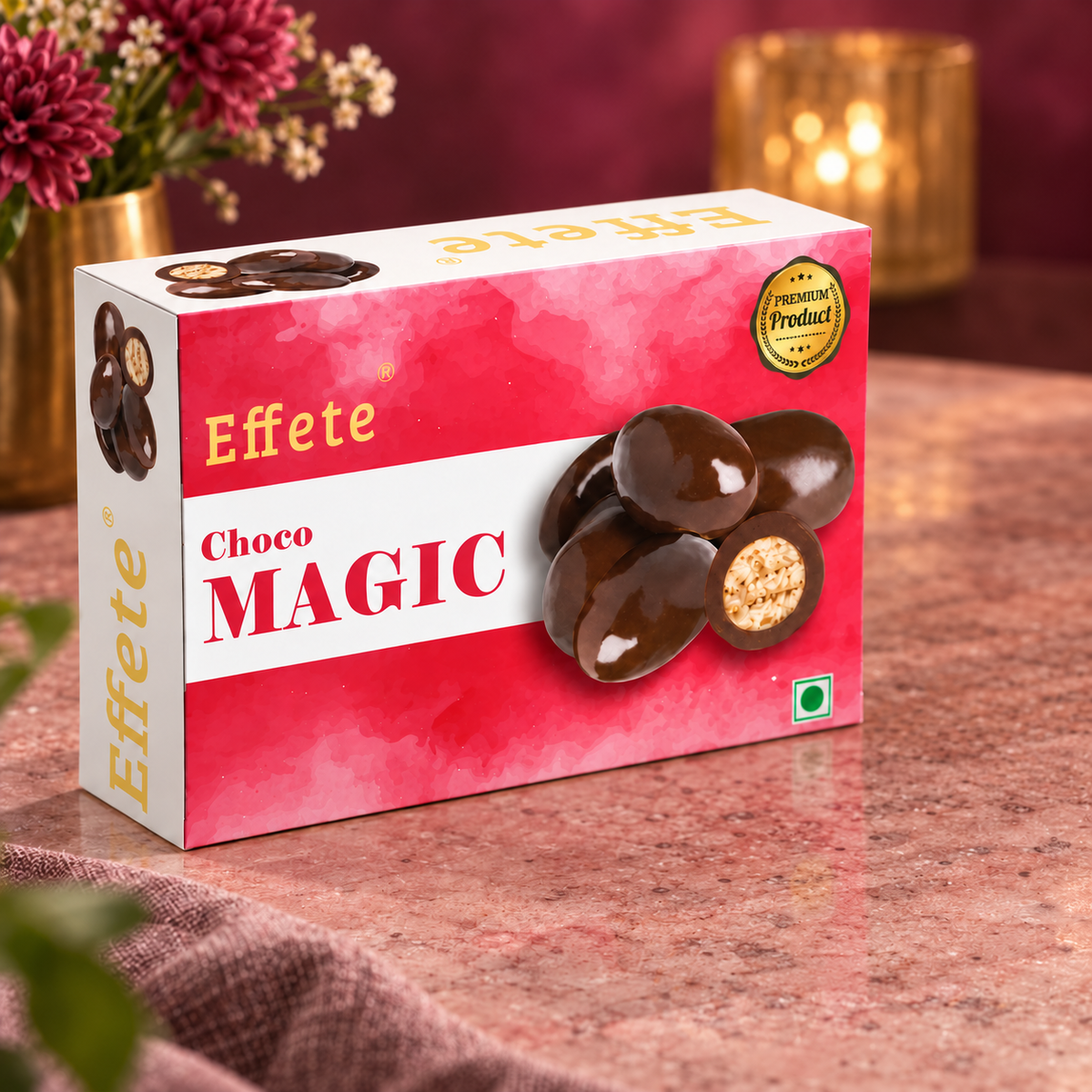 Effete Choco Magic box on a textured pink surface with a blurred background of flowers and candlelight.