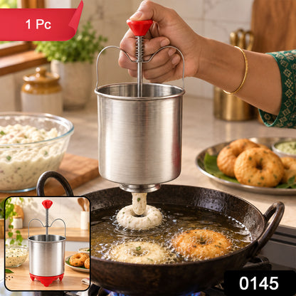 A person uses a stainless steel medu vada maker with a red handle to dispense batter into hot oil, forming a vada. A small