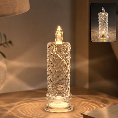 A clear, faceted crystal LED candle glowing warmly on a wooden surface, casting light patterns.