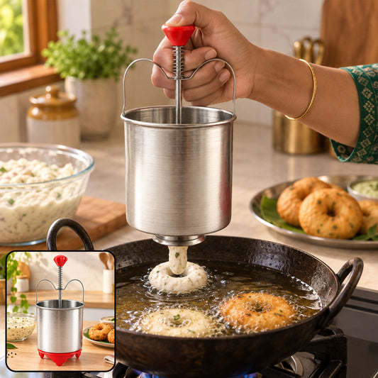 A person uses a stainless steel medu vada maker with a red handle to dispense batter into hot oil, forming a vada.