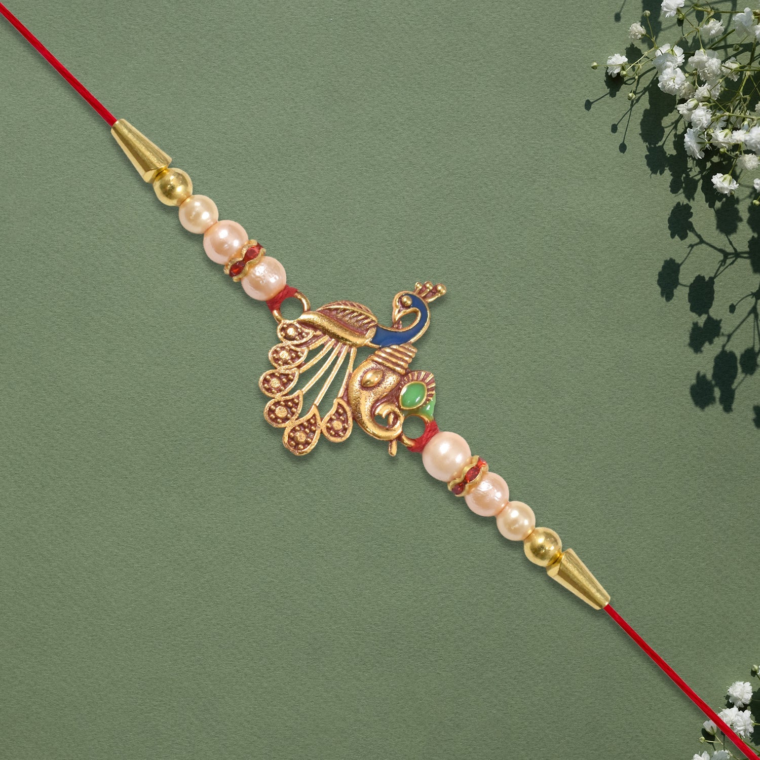 Elegant Peacock Design Rakhi with Pearl Beads and Golden Detailing on Red Thread