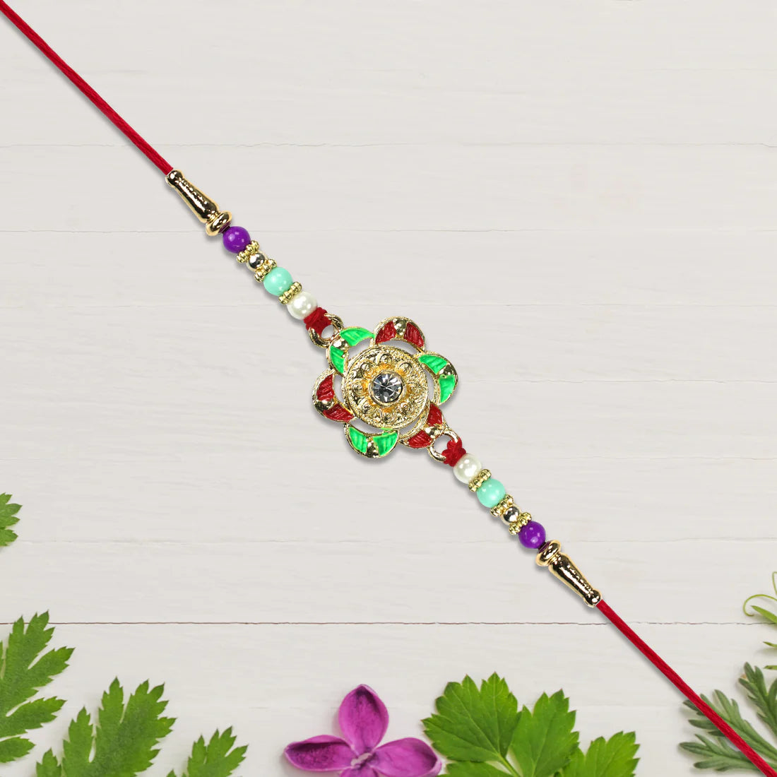Close up view of the elegant floral motif on the Gold Plated Rakhi.