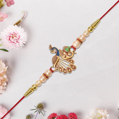 Elegant Peacock Design Rakhi with Pearl Beads and Golden Detailing on Red Thread