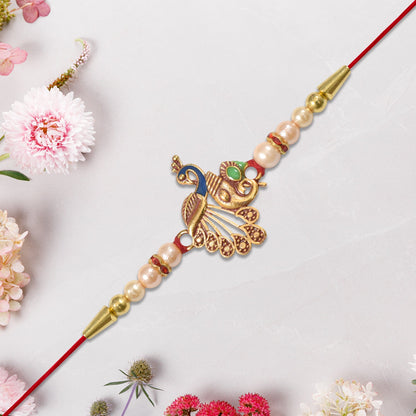 Elegant Peacock Design Rakhi with Pearl Beads and Golden Detailing on Red Thread