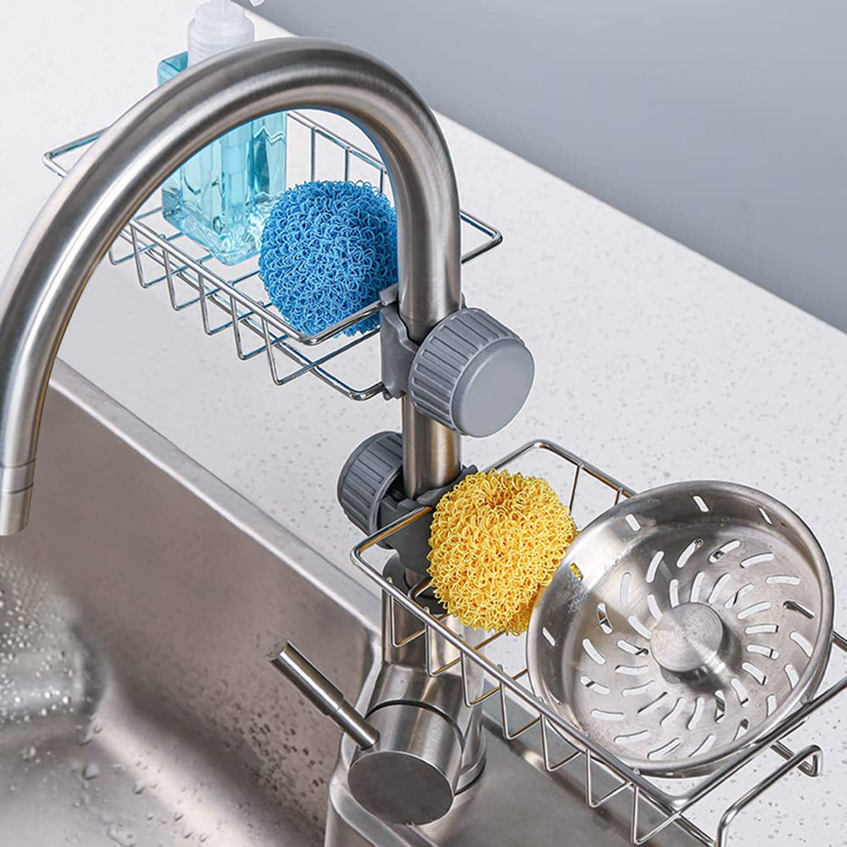 Stainless steel kitchen sink caddy organizer holding soap and scrubbers beside a faucet