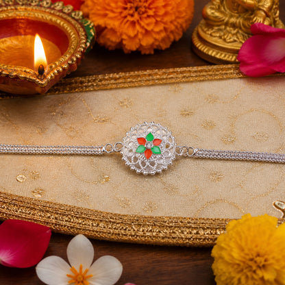 Close-up of silver floral Rakhi design on soft thread