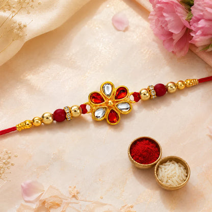 Close-up of a Floral Rakhi with intricate red and gold beaded design.